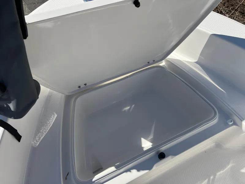 Slide: The Image of 2025 Robalo R160 Center Console storage compartment open, showcasing spacious interior. - 13