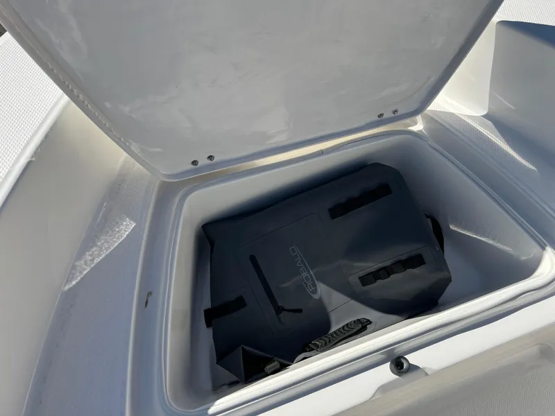 Slide: The Image of Storage compartment of 2025 Robalo R160 Center Console boat, open with contents inside. - 14