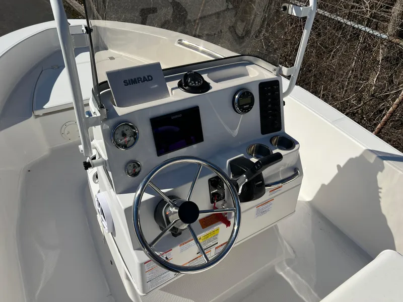Slide: The Image of 2025 Robalo R160 Center Console boat dashboard with steering wheel and navigation controls. - 7