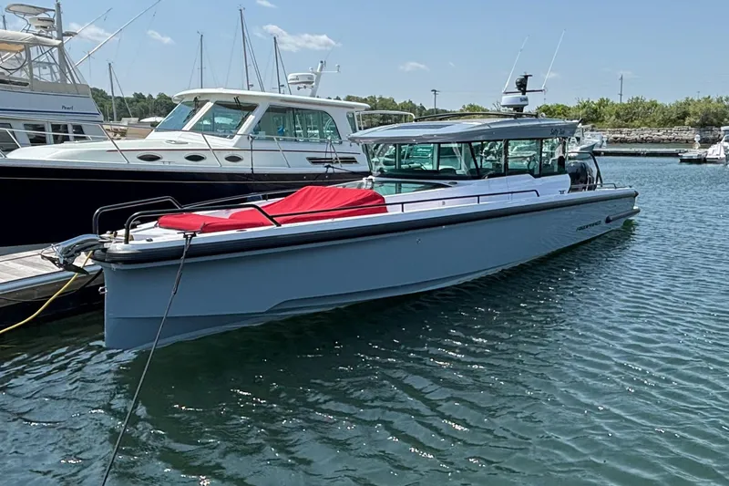 The Image of 2022 Axopar 37XC boat docked in a marina, featuring sleek design and modern amenities. - 0