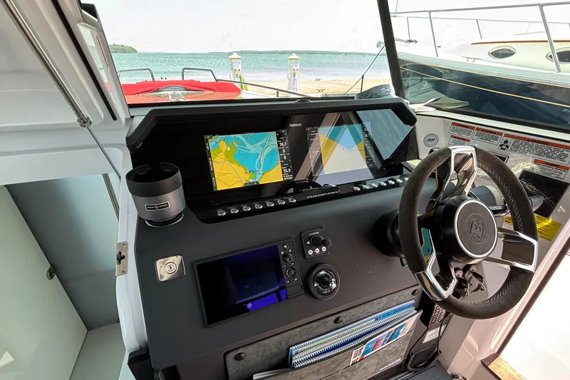 Slide: The Image of Control panel of 2022 Axopar 37XC boat with navigation screens and steering wheel. - 13