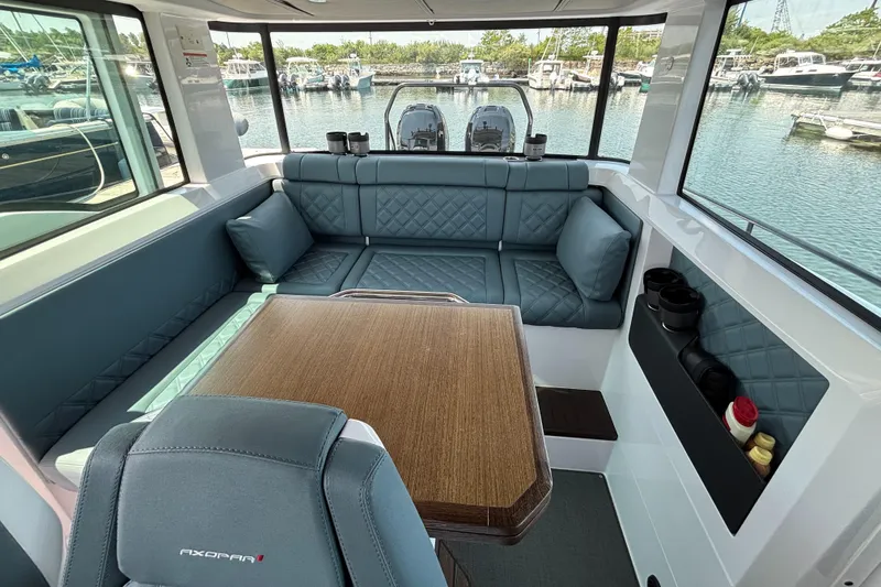 Slide: The Image of Interior of 2022 Axopar 37XC boat with seating and table, docked at marina. - 18