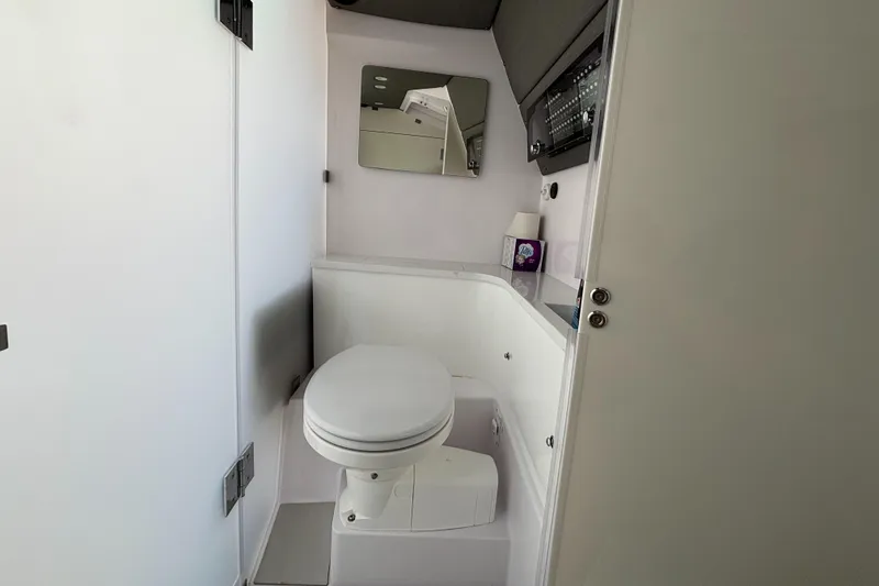 Slide: The Image of 2022 Axopar 37XC boat bathroom with toilet, mirror, and storage. - 22