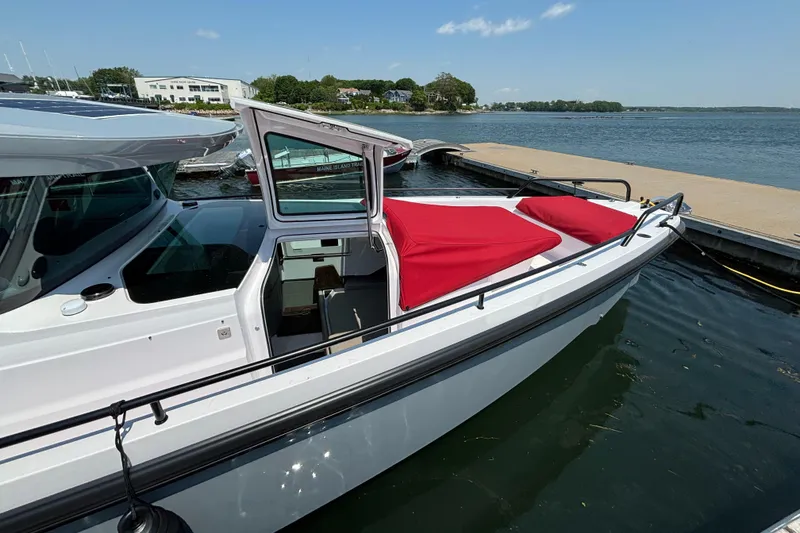 Slide: The Image of 2022 Axopar 37XC boat docked with red cover, side view. - 33