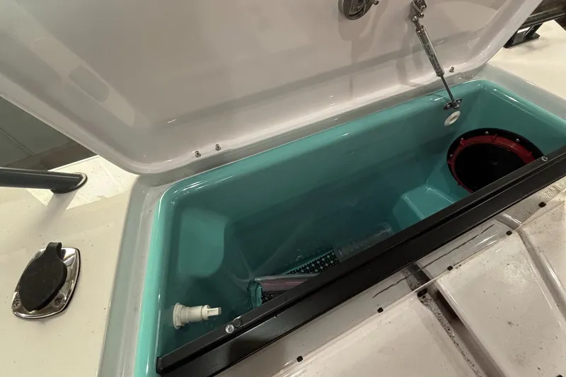 Slide: The Image of Open storage compartment on 2022 Axopar 37XC boat, featuring a turquoise interior. - 38