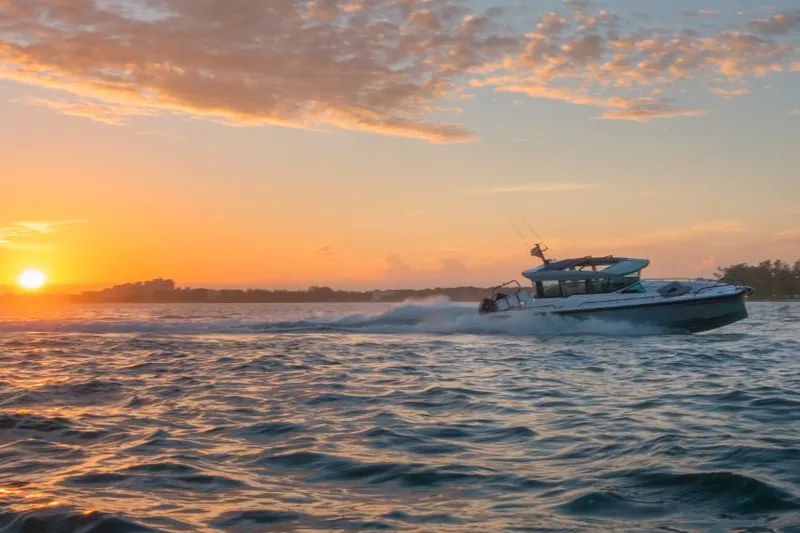Slide: The Image of 2022 Axopar 37XC boat cruising at sunset on open water. - 40