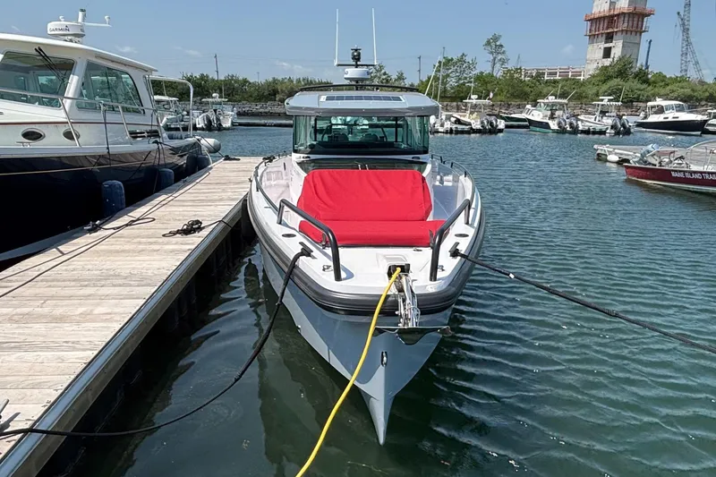 Slide: The Image of 2022 Axopar 37XC boat docked with red seating, surrounded by other boats. - 6