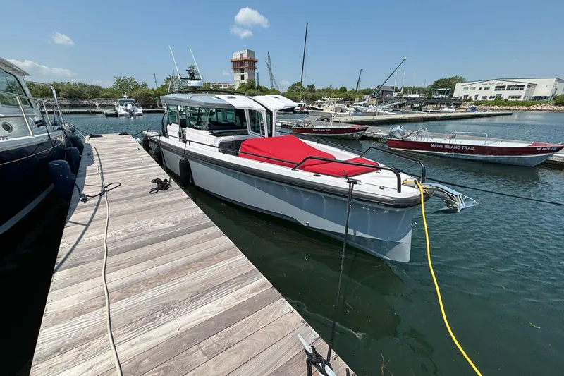 Slide: The Image of 2022 Axopar 37XC boat docked at marina with red cover. - 8