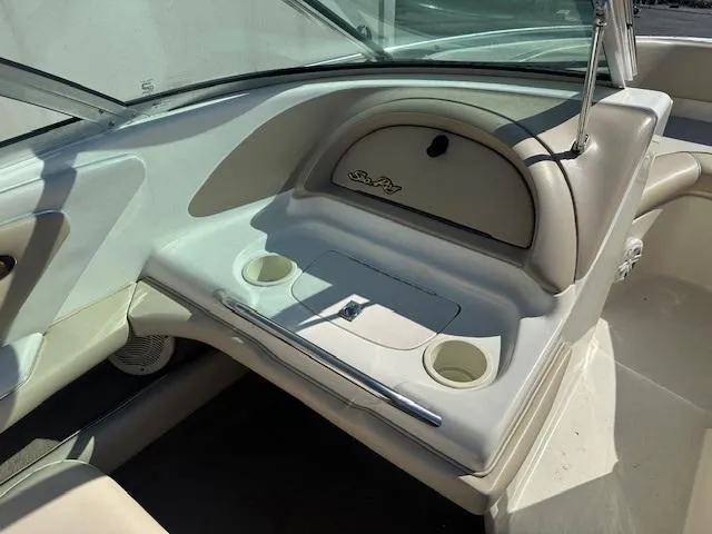 Slide: The Image of 1997 Sea Ray 210 Bowrider interior with cup holders and storage compartment. - 4