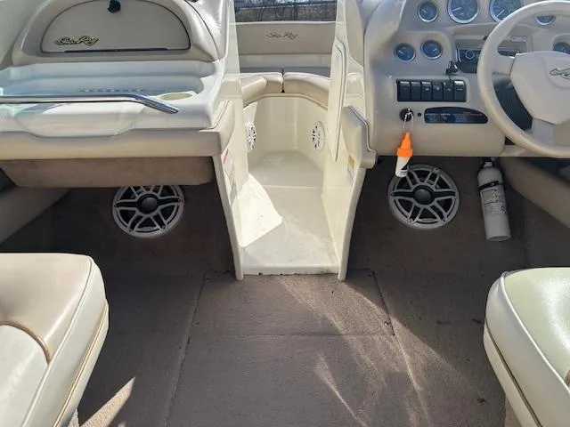 Slide: The Image of 1997 Sea Ray 210 Bowrider interior, featuring beige upholstery and dashboard controls. - 5