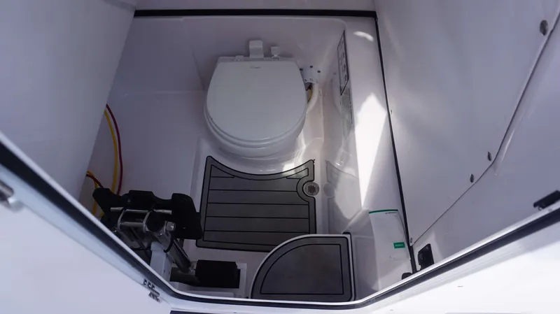 Slide: The Image of 2025 Sportsman 262 Open boat interior with compact marine toilet and flooring. - 16