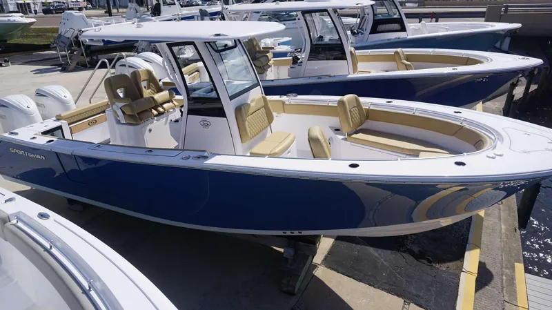 Slide: The Image of 2025 Sportsman 262 Open boat with blue hull, docked alongside similar models. - 18