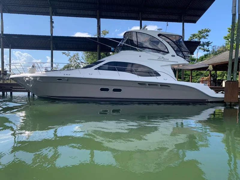 The Image of 2006 Sea Ray 52 Sedan Bridge yacht docked in a marina. - 1