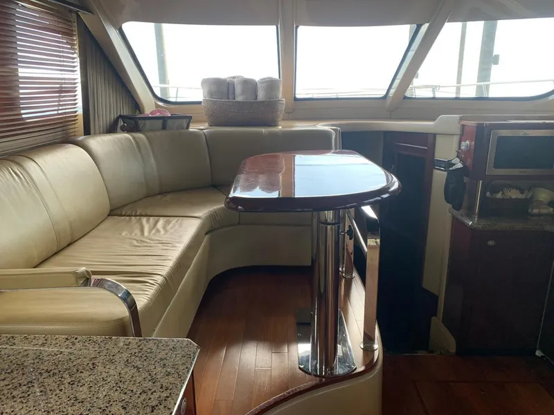 Slide: The Image of Interior of 2006 Sea Ray 52 Sedan Bridge yacht with leather seating and wooden table. - 17