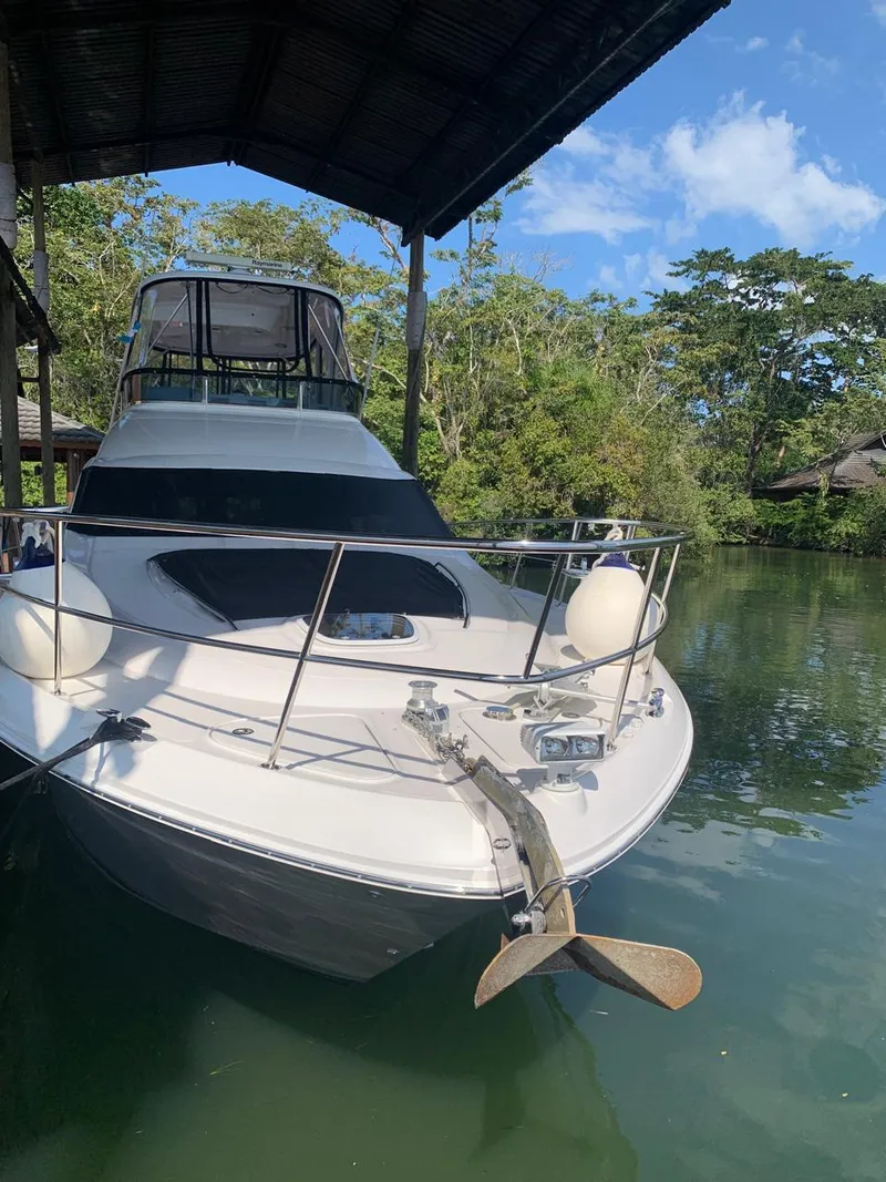 Slide: The Image of 2006 Sea Ray 52 Sedan Bridge yacht docked in a serene, wooded area. - 4