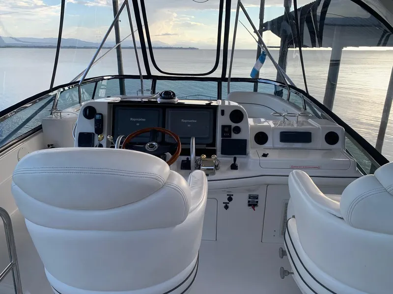 Slide: The Image of 2006 Sea Ray 52 Sedan Bridge helm with dual white captain chairs and navigation equipment. - 5