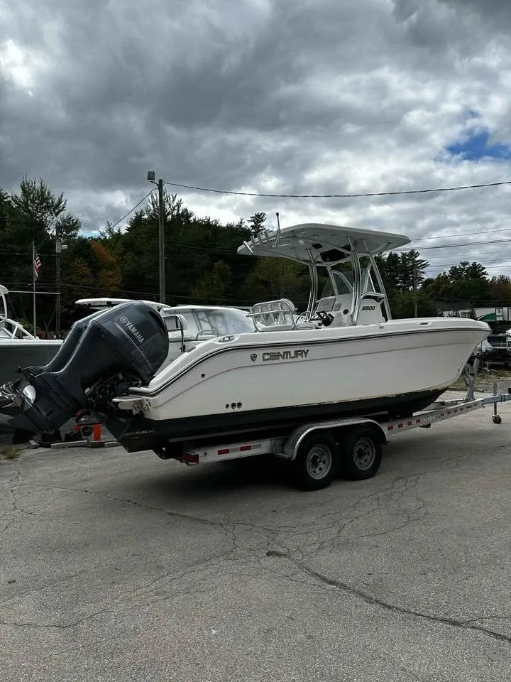 Slide: The Image of 2015 Century 2600 CC boat on trailer, parked outdoors under cloudy sky. - 1