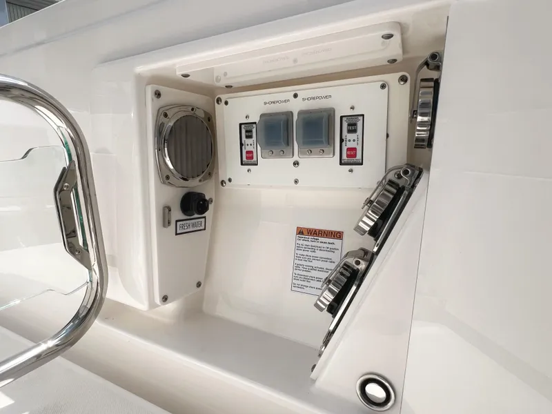 Slide: The Image of Control panel on 2023 Tiara Yachts 38 LS boat, featuring switches and warning label. - 12