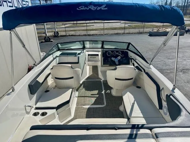 Slide: The Image of 2018 Sea Ray SPX 210 boat interior with seating and steering wheel, under blue canopy. - 5