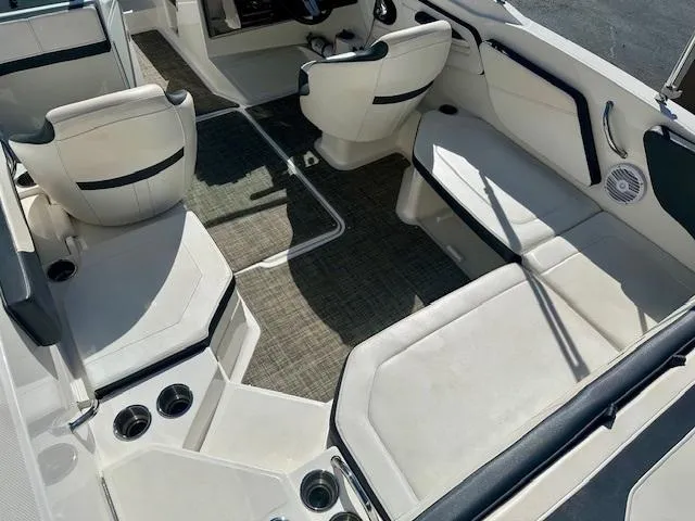 Slide: The Image of 2018 Sea Ray SPX 210 boat interior with white seating and carpeted flooring. - 6