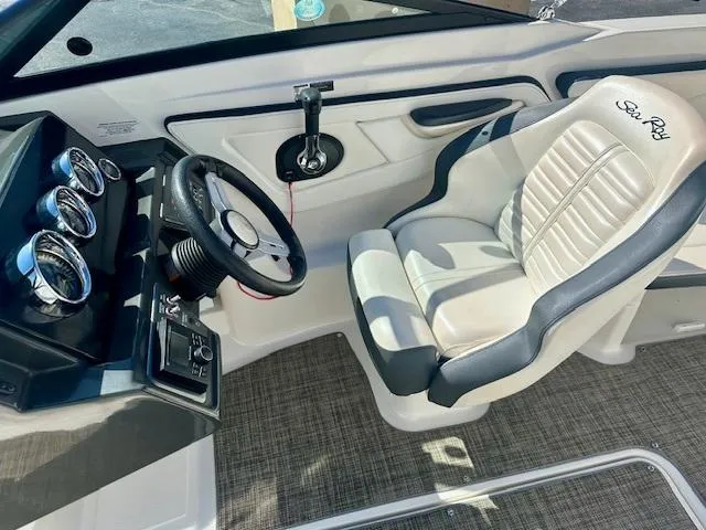 Slide: The Image of 2018 Sea Ray SPX 210 boat interior with steering wheel and cushioned seat. - 8