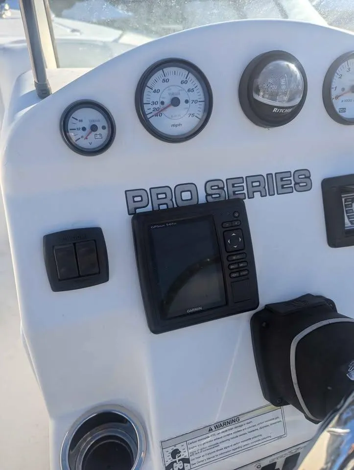 Slide: The Image of Dashboard of a 2012 Sea Fox 236CC Pro Series boat with gauges and controls. - 15