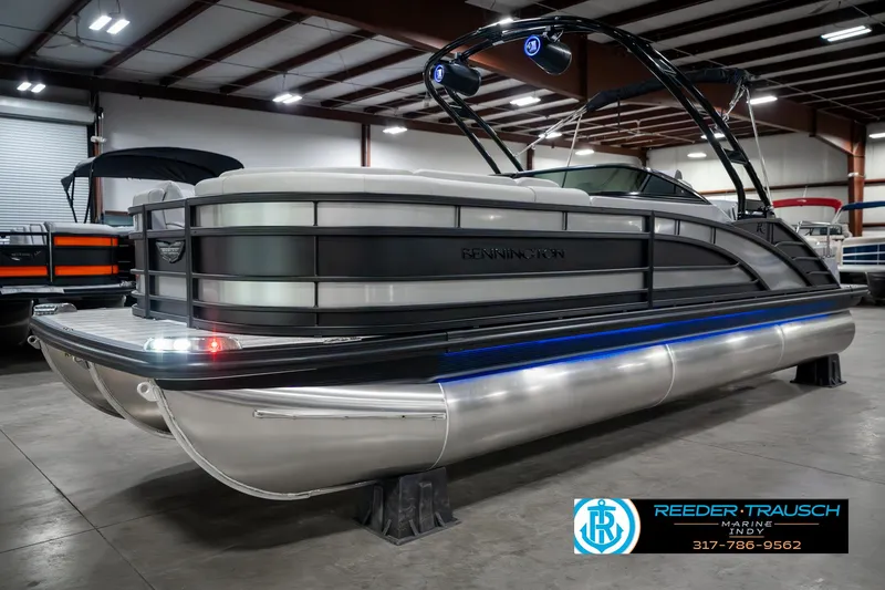 Slide: The Image of 2025 Bennington 23 RSBWA pontoon boat in showroom, featuring sleek design and modern lighting. - 2