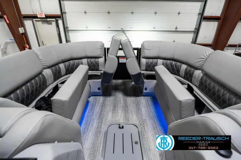 Slide: The Image of 2025 Bennington 23 RSBWA pontoon boat interior with gray seating and blue accent lighting. - 22