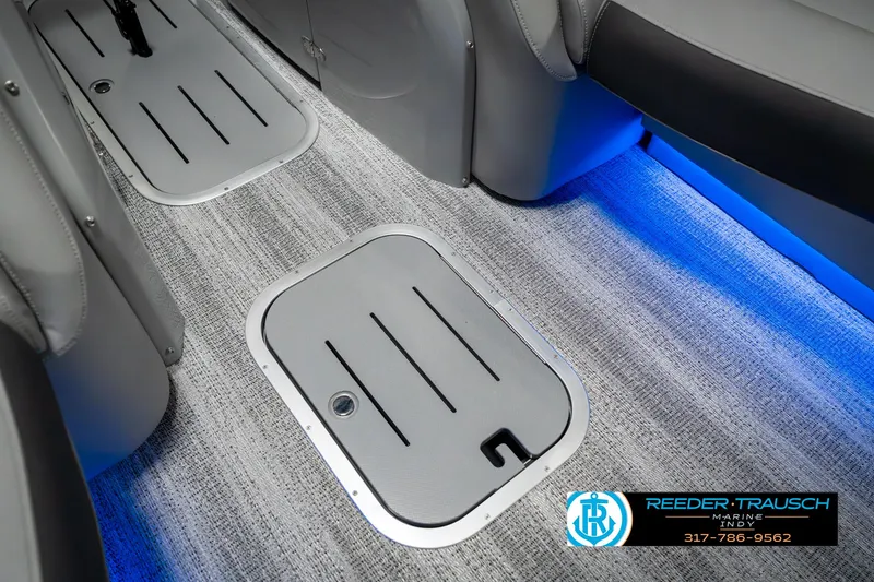 Slide: The Image of 2025 Bennington 23 RSBWA interior with blue LED lighting and carpeted flooring. - 23