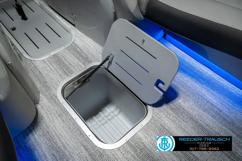 Slide: The Image of 2025 Bennington 23 RSBWA boat interior storage compartment with blue LED lighting. - 24
