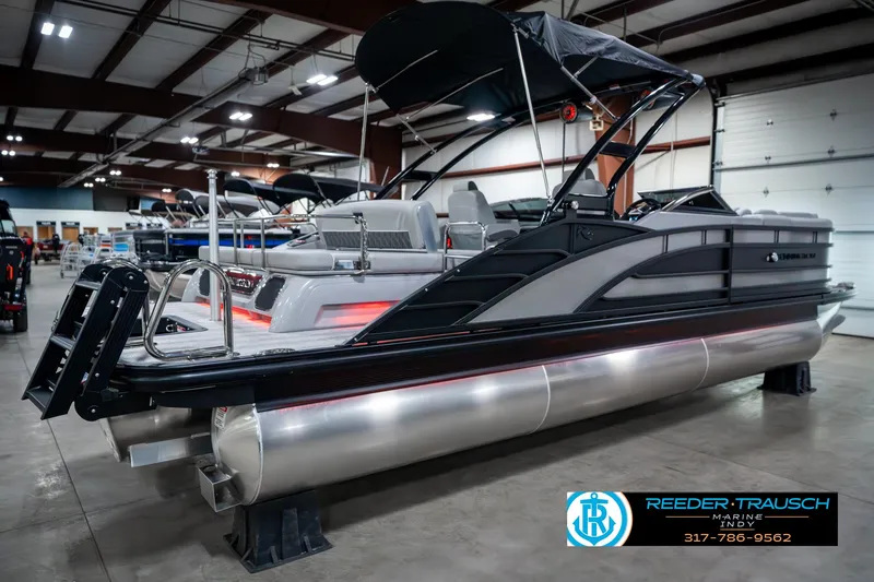 Slide: The Image of 2025 Bennington 23 RSBWA pontoon boat displayed indoors at Reeder-Trausch Marine showroom. - 7