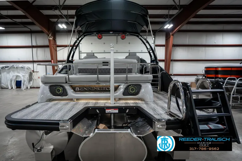 Slide: The Image of 2025 Bennington 23 RSBWA pontoon boat in a showroom, rear view with ladder and seating. - 8