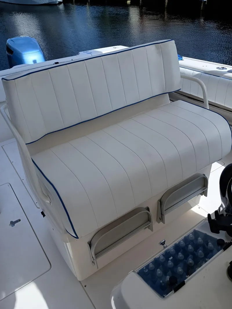 Slide: The Image of 1998 Intrepid 356 Center Console Cuddy boat with white cushioned seating. - 10