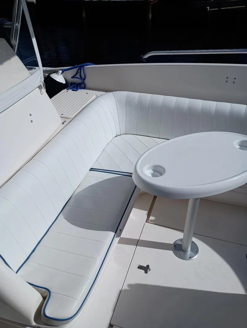 Slide: The Image of 1998 Intrepid 356 Center Console Cuddy with white seating and table in the cockpit area. - 12