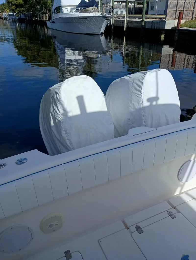 Slide: The Image of 1998 Intrepid 356 Center Console Cuddy with covered engines docked by water. - 15