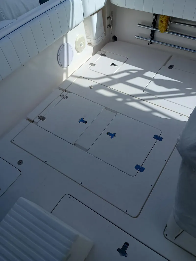 Slide: The Image of 1998 Intrepid 356 Center Console Cuddy boat deck with storage compartments. - 16