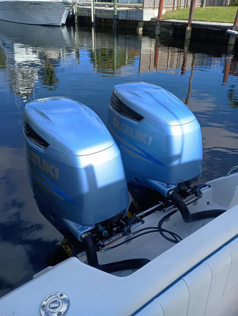 Slide: The Image of Twin outboard motors on a 1998 Intrepid 356 Center Console Cuddy boat docked by the water. - 17