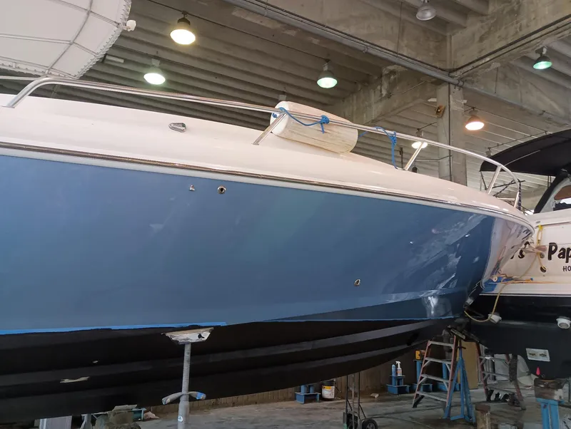 Slide: The Image of 1998 Intrepid 356 Center Console Cuddy boat in a maintenance facility. - 4