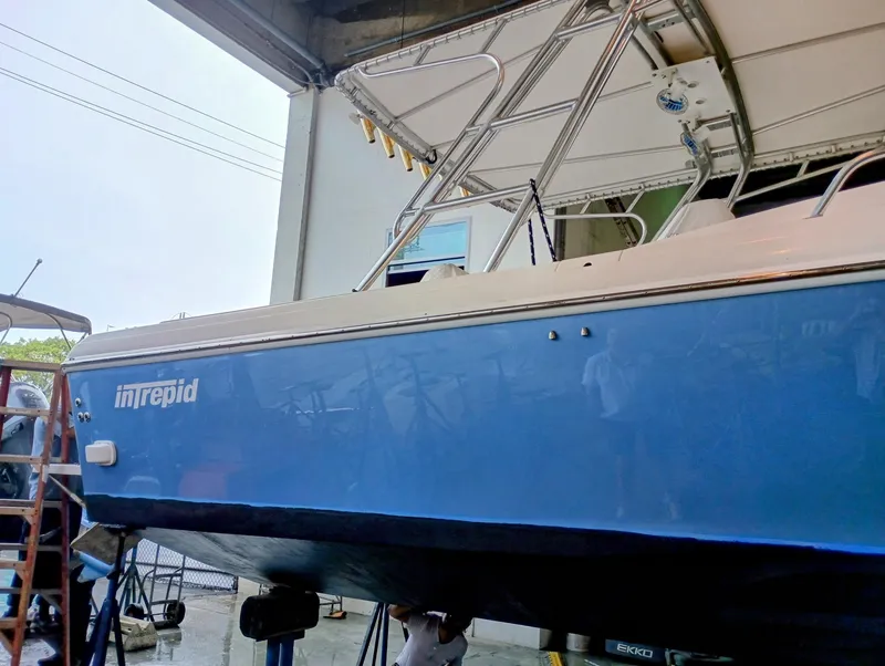 Slide: The Image of 1998 Intrepid 356 Center Console Cuddy boat in dry dock, blue hull, side view. - 6