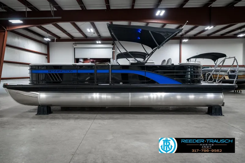 Slide: The Image of 2025 Bennington 25 LPD pontoon boat in a showroom with blue accents. - 11