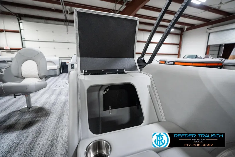 Slide: The Image of 2025 Bennington 25 LPD interior with open storage compartment and cup holder. - 29