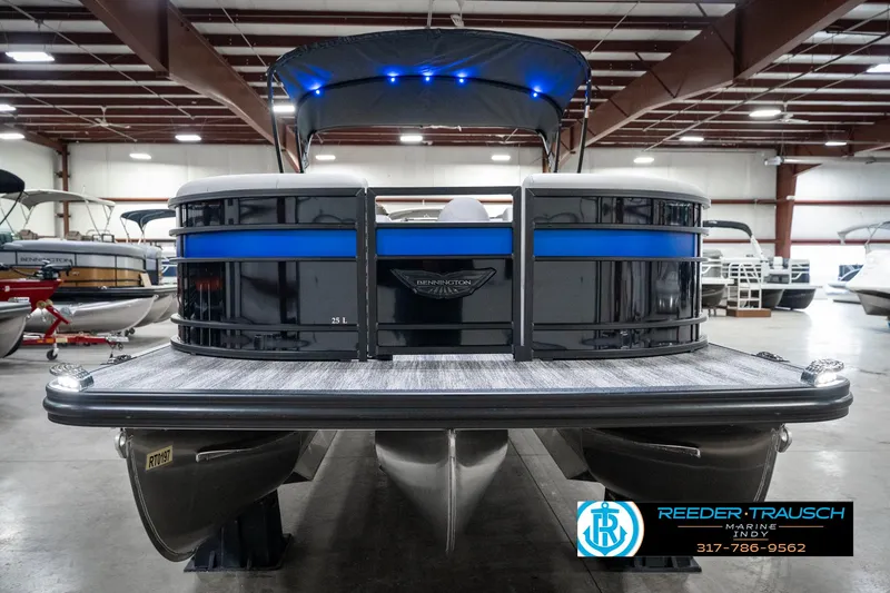 Slide: The Image of 2025 Bennington 25 LPD pontoon boat in showroom with blue LED lights. - 5
