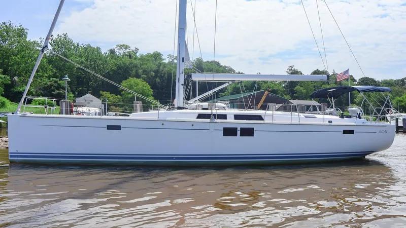 Slide: The Image of 2018 Hanse 505 sailboat docked on a calm river, surrounded by greenery. - 0
