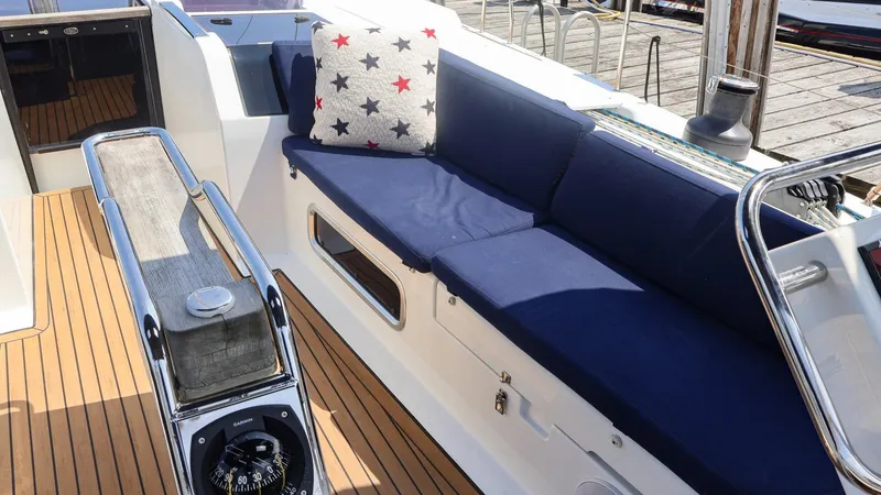 Slide: The Image of 2018 Hanse 505 yacht interior with blue seating and star-patterned pillow. - 18