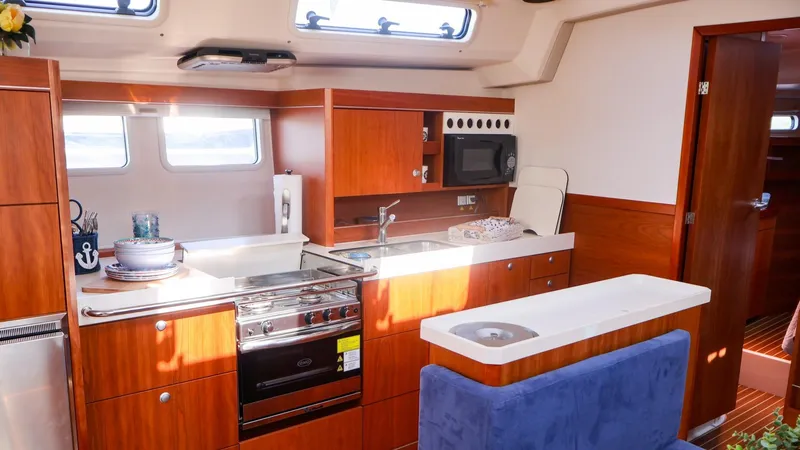 Slide: The Image of Interior of 2018 Hanse 505 yacht featuring a modern kitchen with wood cabinetry. - 24