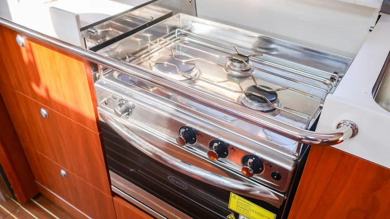 Slide: The Image of Modern kitchen stove on 2018 Hanse 505 yacht, featuring a sleek stainless steel design. - 25
