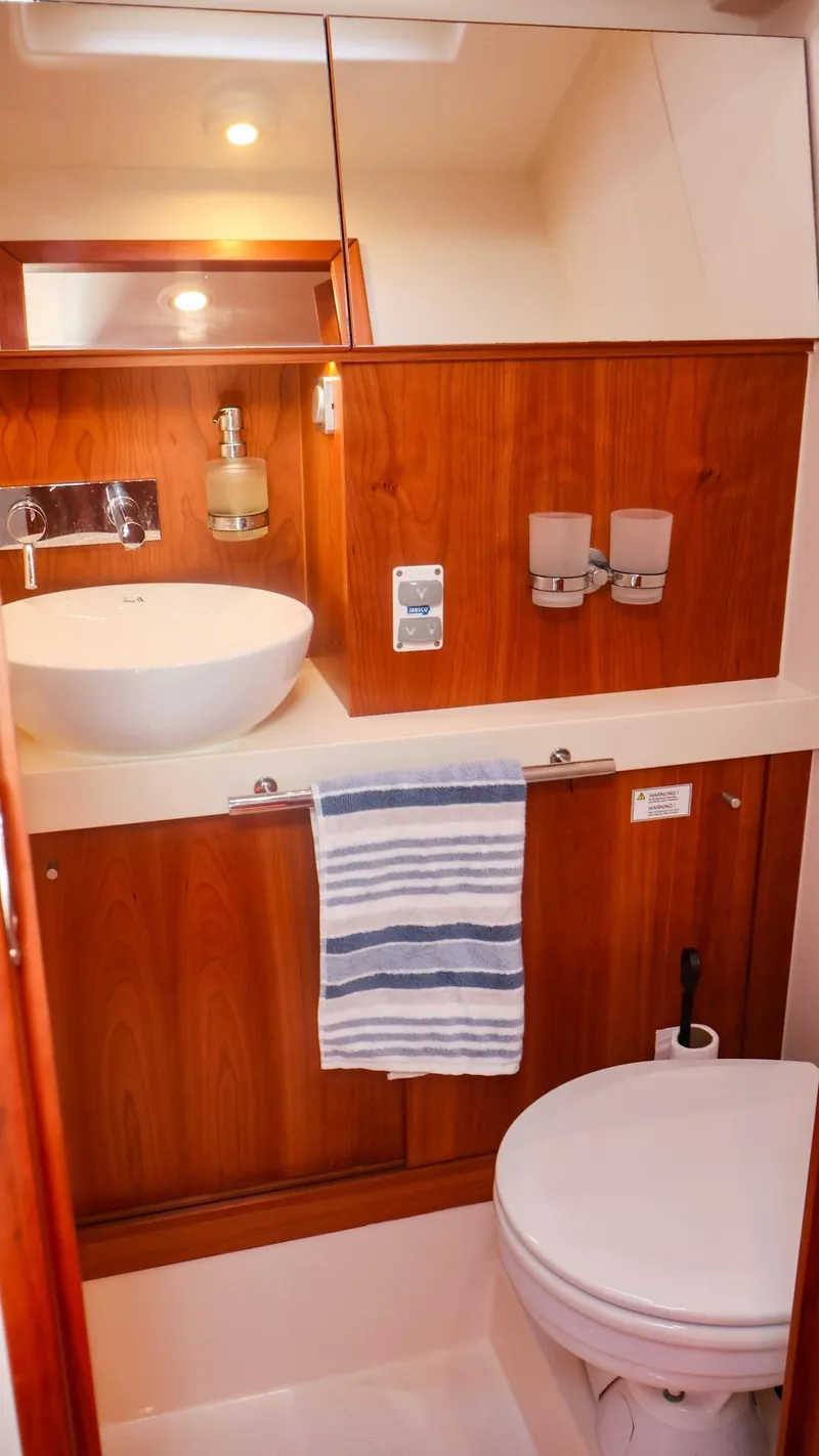 Slide: The Image of 2018 Hanse 505 yacht bathroom with wooden cabinetry, modern sink, and toilet. - 29