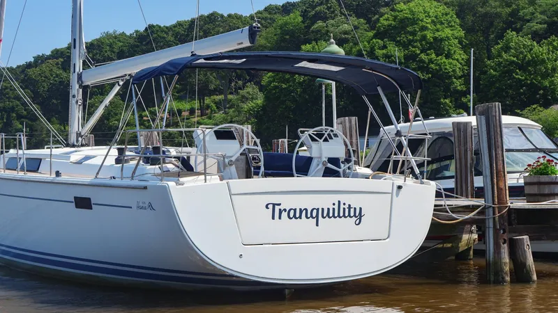 Slide: The Image of Hanse 505 sailboat named "Tranquility" docked by lush greenery, 2018 model. - 35