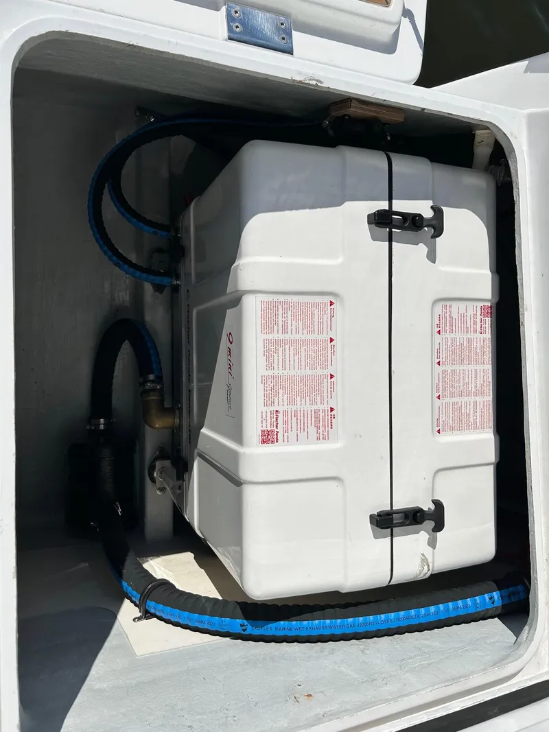 Slide: The Image of Hanse 505 2018 yacht compartment with secured white storage container and blue hoses. - 38