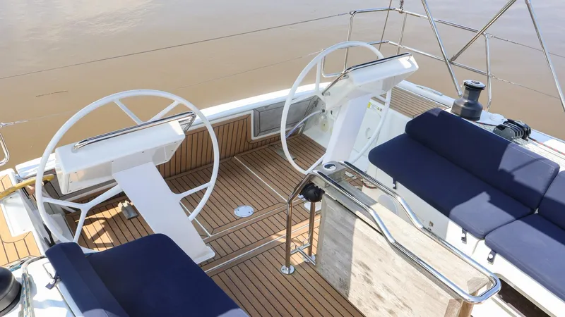 Slide: The Image of 2018 Hanse 505 yacht cockpit with dual steering wheels and blue cushioned seating. - 9